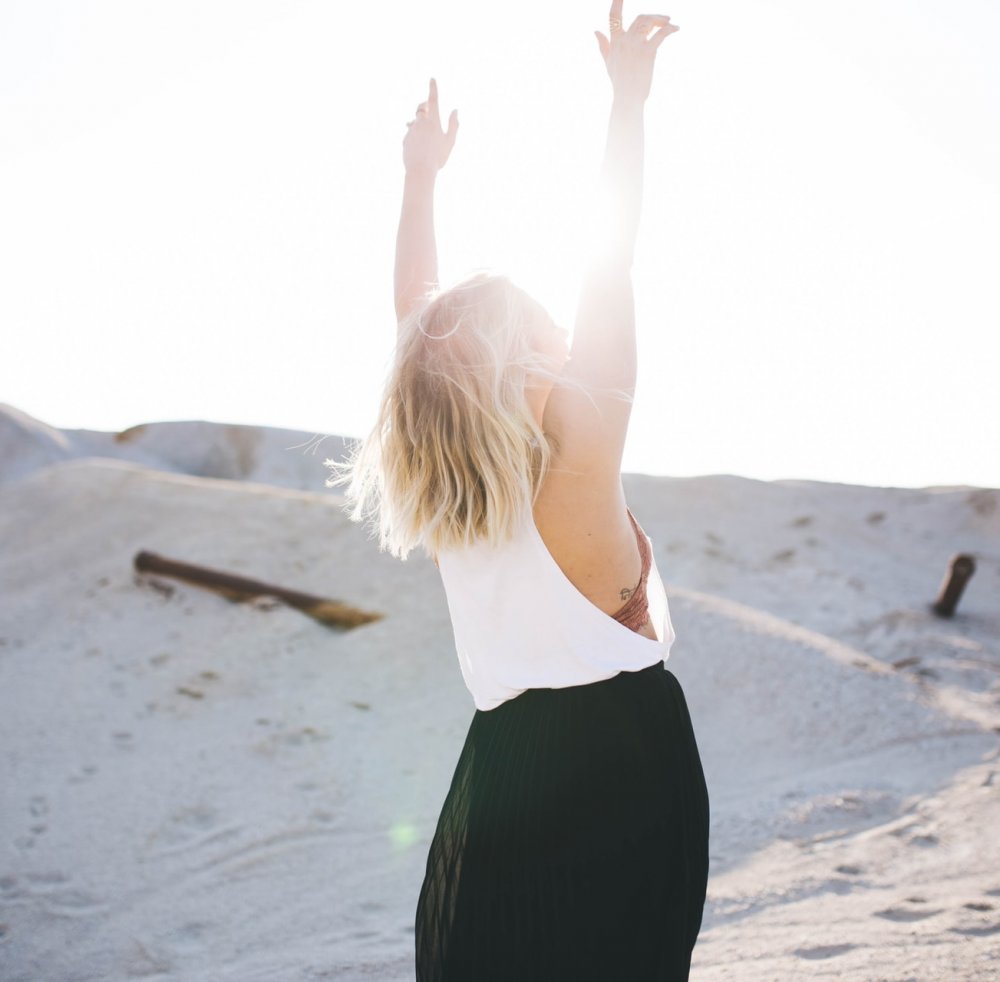 Woman with her hands in the air at beach