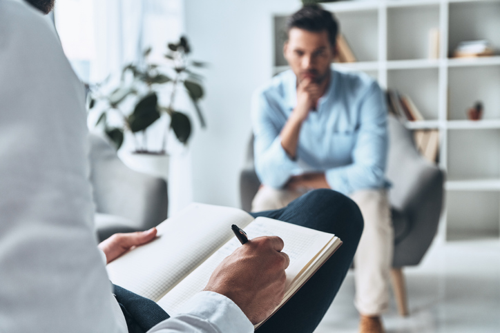 Young man having a therapy session with psychologist