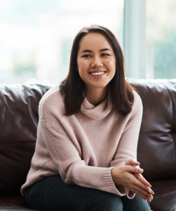 Woman smiling and sitting on sofa