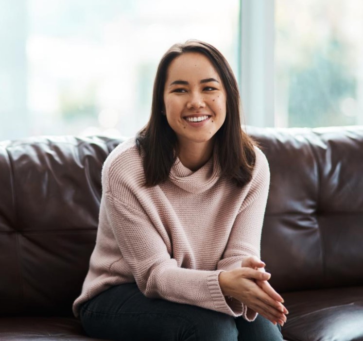 Woman smiling and sitting on sofa