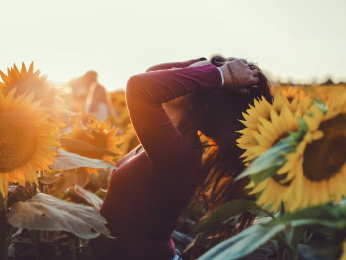 Happy relieved woman in a field of sunflowers