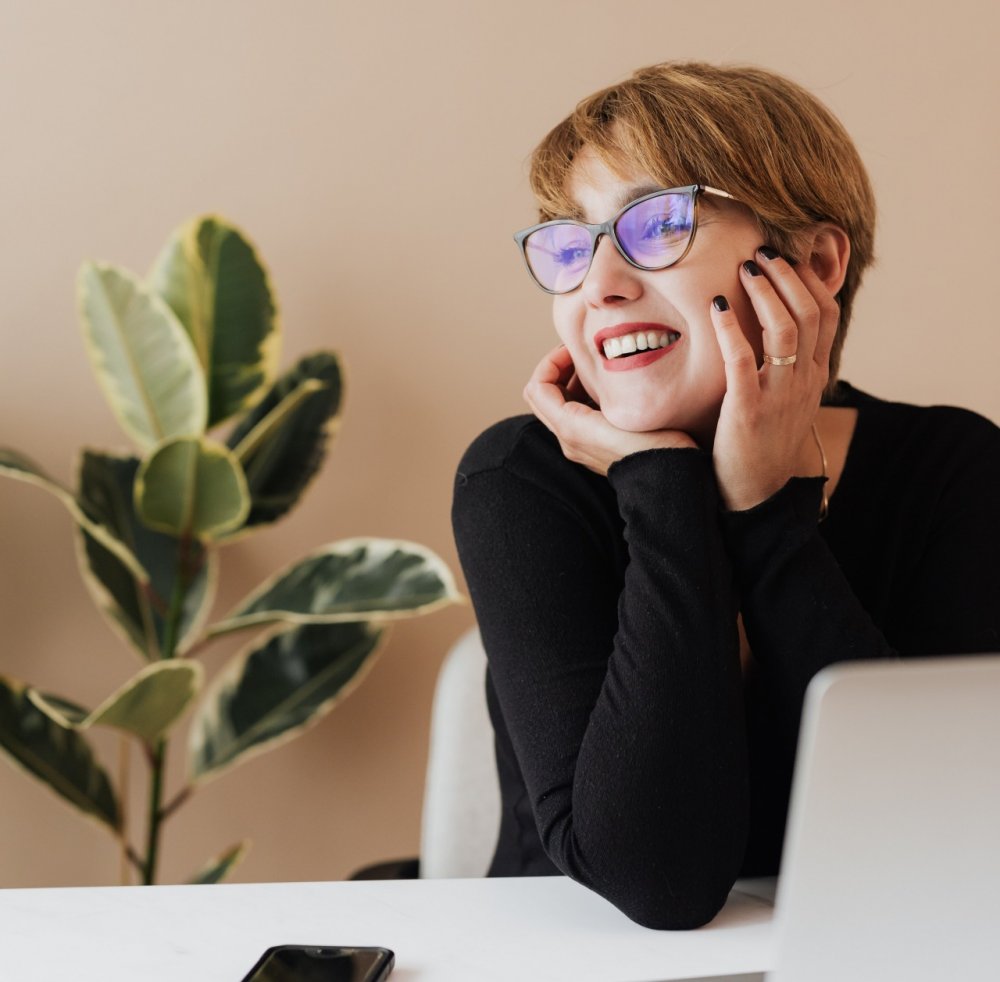 A young psychologist smiles while working on her laptop